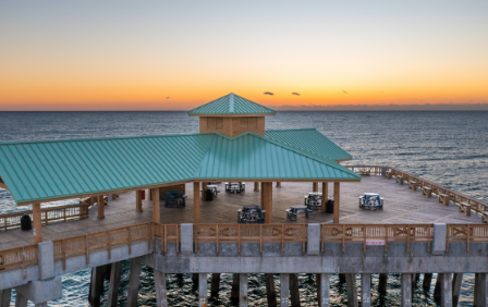 Bachelorette group posing on the Folly Beach Pier at golden hour